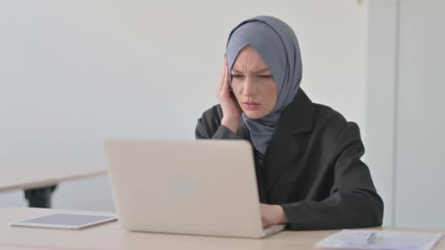 Woman Experiences Headache at her Desk