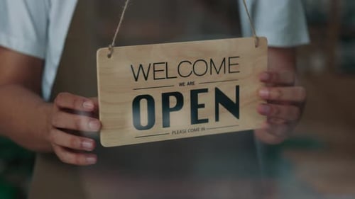 Closeup Shot of Worker Hands Turning Sign Sorry We are Closed on Cafe Door