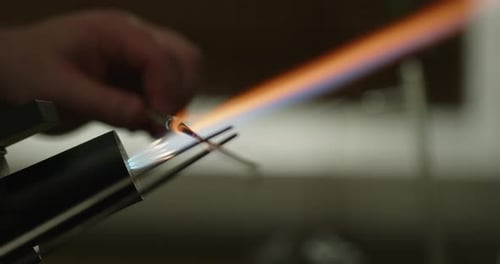 Glasbläserkünstler verwendet beim Trennen von Glasstäben eine Zange