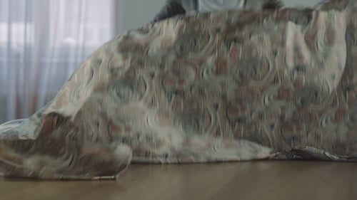 Woman Spreading Decorative Fabric on Table Indoors