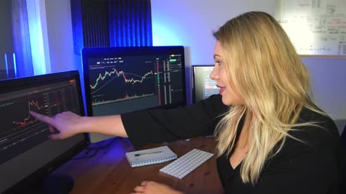 Woman Analyzing Stock Market Data on Computer Screens
