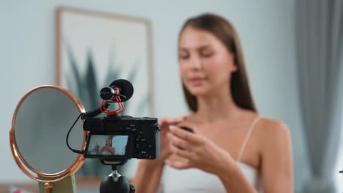 Woman filming beauty tutorial in her bright home
