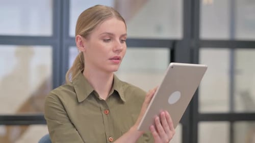Woman Works on Tablet in Workplace