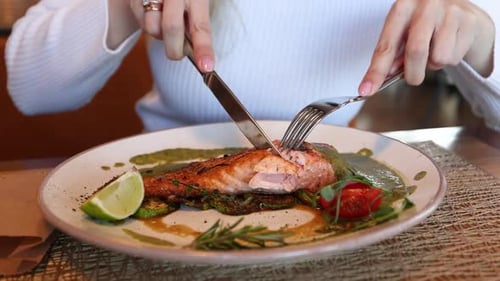 Mädchen isst gekochten gegrillten Lachs. Nahaufnahmen