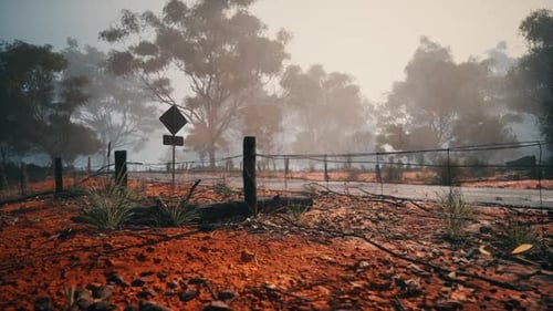 Dirt Field With Fence and Street Sign