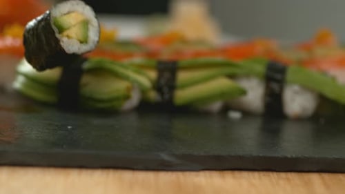 Köstliche Sushi-Rollen, die von einem Koch in Zeitlupe zubereitet werden