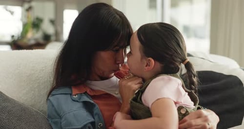 Woman and Child Embracing on Couch at Home