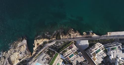 Aerial view of rocky coastline and buildings, Malta.