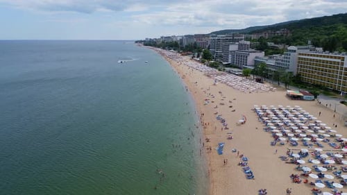 Aerial View of a Picturesque Beach Lined with Umbrellas and People Enjoying a Sunny Day By the Sea