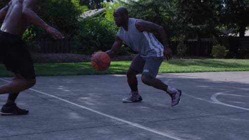 Street basketball player dribbling ball down court in New York City slow motion