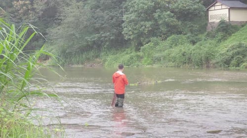The fisherman is fishing in the stream