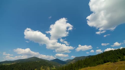 Green Mountains and Clouds Under a Blue Sky