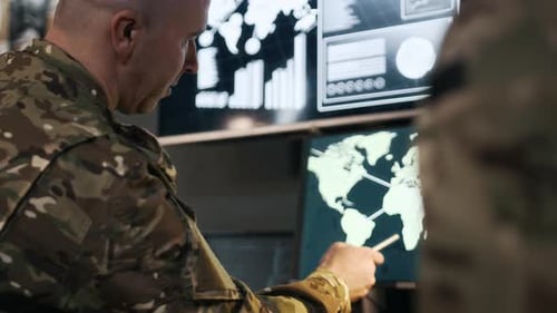 Soldiers Analyze World Map on Computer Screens