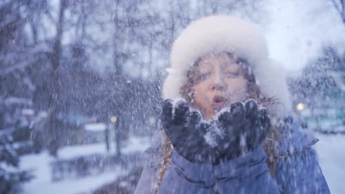 Woman Blowing Snow in Winter Park