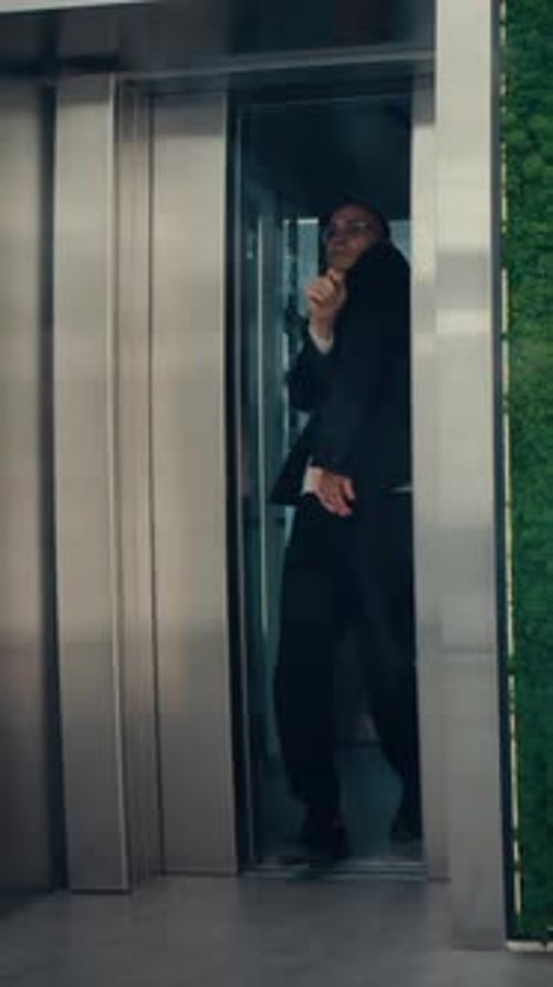 Vertical of Businessman Dancing in Elevator