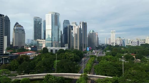 A city with tall buildings and a bridge over a highway