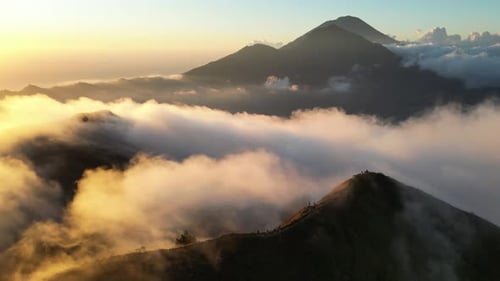 Drone shot of Batur volcano summit in clouds at sunrise, Bali, Indonesia