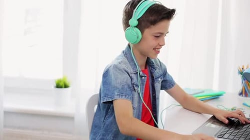 Technologie-, Spiel- und Menschenkonzept - Junge mit Kopfhörern spielt Videospiel