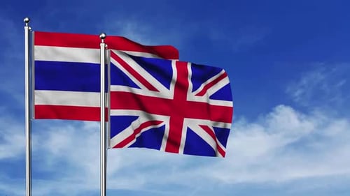 Thailand and United Kingdom Flags Waving in Blue Sky