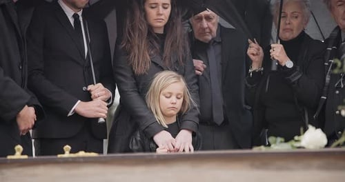 Mournful Group at Graveside Service on Overcast Day