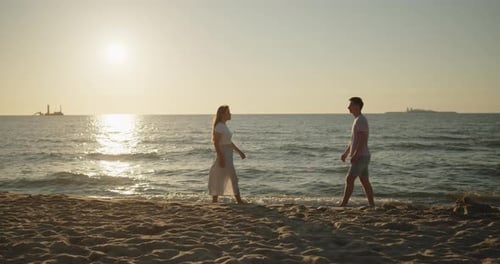 Young Loving Couple Enjoying Relaxing Sunset Walk on the Beach