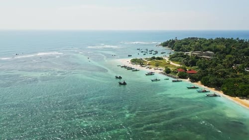 Aerial View of Tranquil Blue Lagoon Fishing Vessels at Sea Tropical Coast Tourism Serene Escape