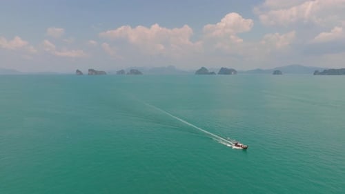 4K aerial drone footage of long tail boat exploring Thai islands, Andaman see, Thailand, Asia