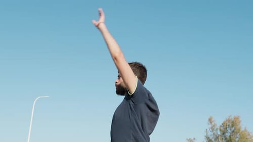 Man Stretching Arms Outdoors on Sunny Day