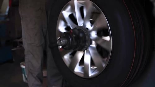 Car wheel service. Mechanic changing tires and rims, balancing the wheels