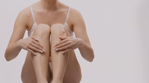 Woman Applies Moisturizing Cream on Legs