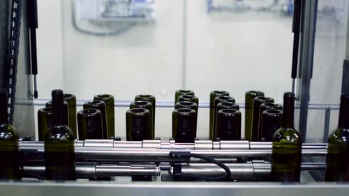 Wine Bottle Conveyor Operation in a Busy Factory Setting with Red and White Bottles Moving Along the