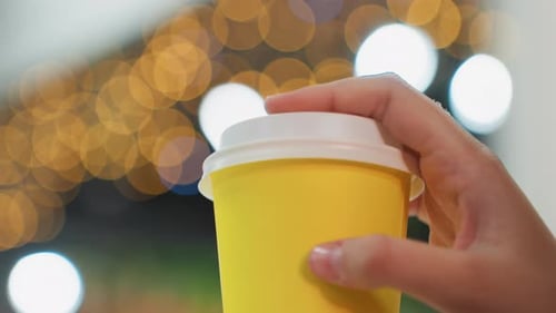 Close Up of Hand Holding a Yellow Cup