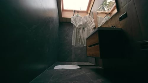 Modern Bathroom Interior with Dark Marble and Robes