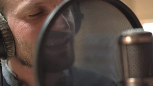 Singers face in front of studio microphone, extreme closeup