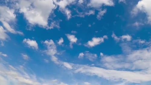 Schöne kleine weiße Wolken fliegen am Himmel und zerstreuen sich im Wind. Niedriger Blickwinkel. Zeitraffer
.