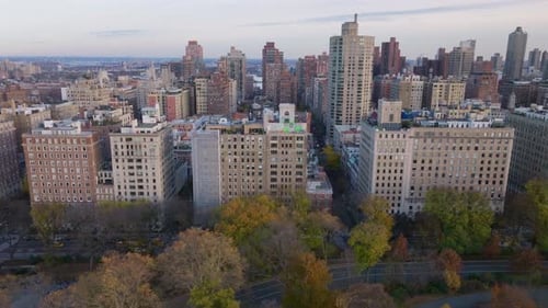 Aerial Footage Displaying New York City Skyline at Dusk with Illuminated Buildings and Tranquil