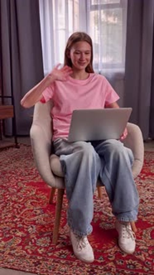 Young Woman in Living Room Frowning at Laptop Screen