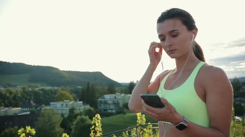 Woman with Smartphone Prepares to Exercise Outdoors
