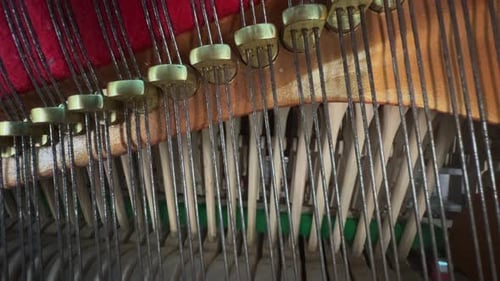 Close-up of piano hammers striking strings inside a piano