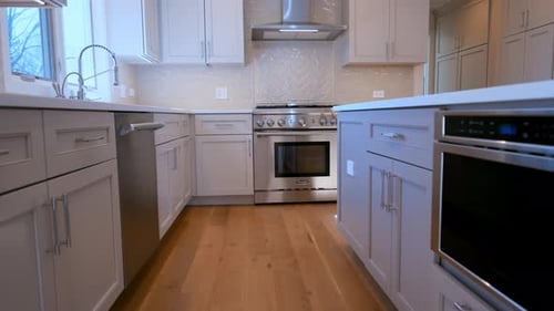 Modern Residential Kitchen with White Cabinets Stainless Steel Oven Range Hood and Wooden Floor