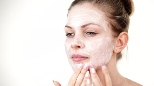 Woman Applying Mask Cream On Face