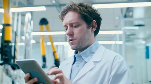 Männlicher Wissenschaftler analysiert Daten auf einem digitalen Tablet im Labor