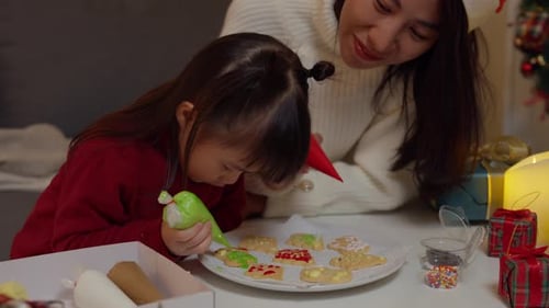 Child and Adult Decorate Christmas Cookies Together