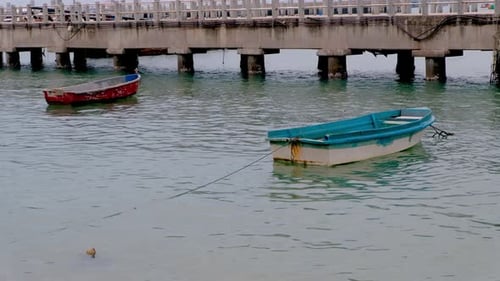 Two old row boats moored at a dock in Thailand