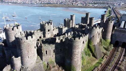 Medieval Conwy castle Welsh market town ruins aerial descending Birdseye view historical harbour