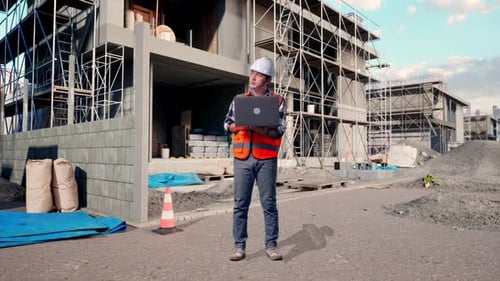 Full Body Of Asian Male Engineer Working On A Laptop At Building Site