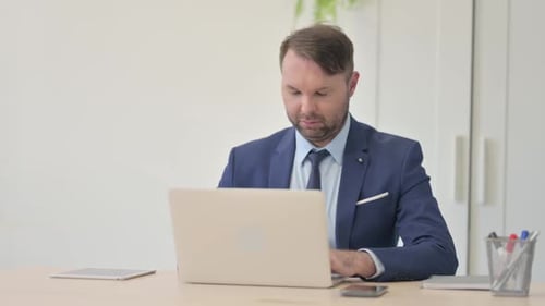 Vielbeschäftigter Geschäftsmann arbeitet am Laptop