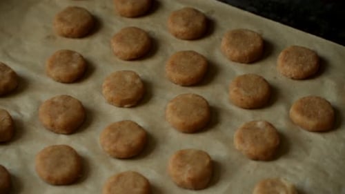 Baker Putting Tray of Raw Cookies in Oven