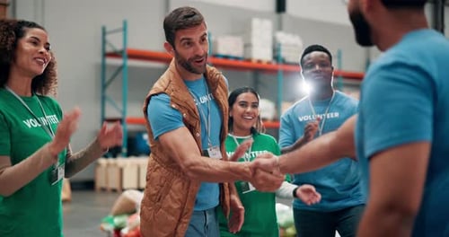 Volunteers Shaking Hands in a Warehouse