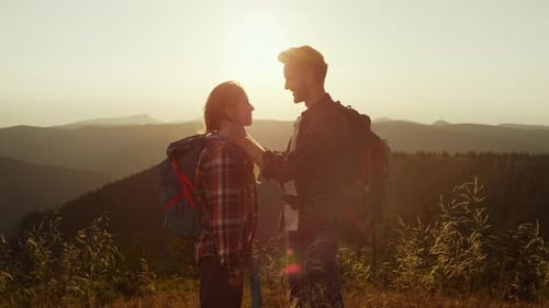 Couple Hiking in Mountains at Sunset Embrace